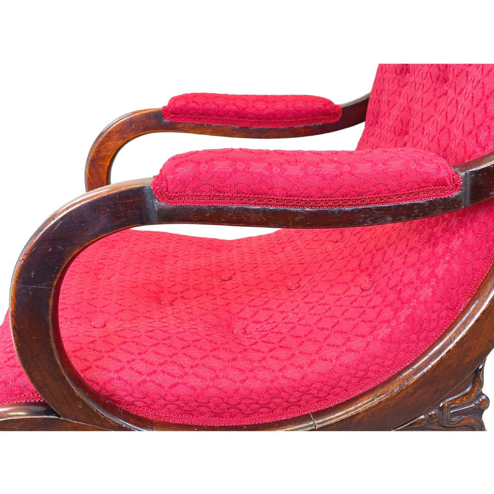 A Regency mahogany library armchair featuring button-backed red upholstery, curved scroll arms, and brass castors. View V