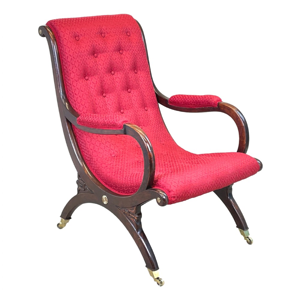 A Regency mahogany library armchair featuring button-backed red upholstery, curved scroll arms, and brass castors. View VII