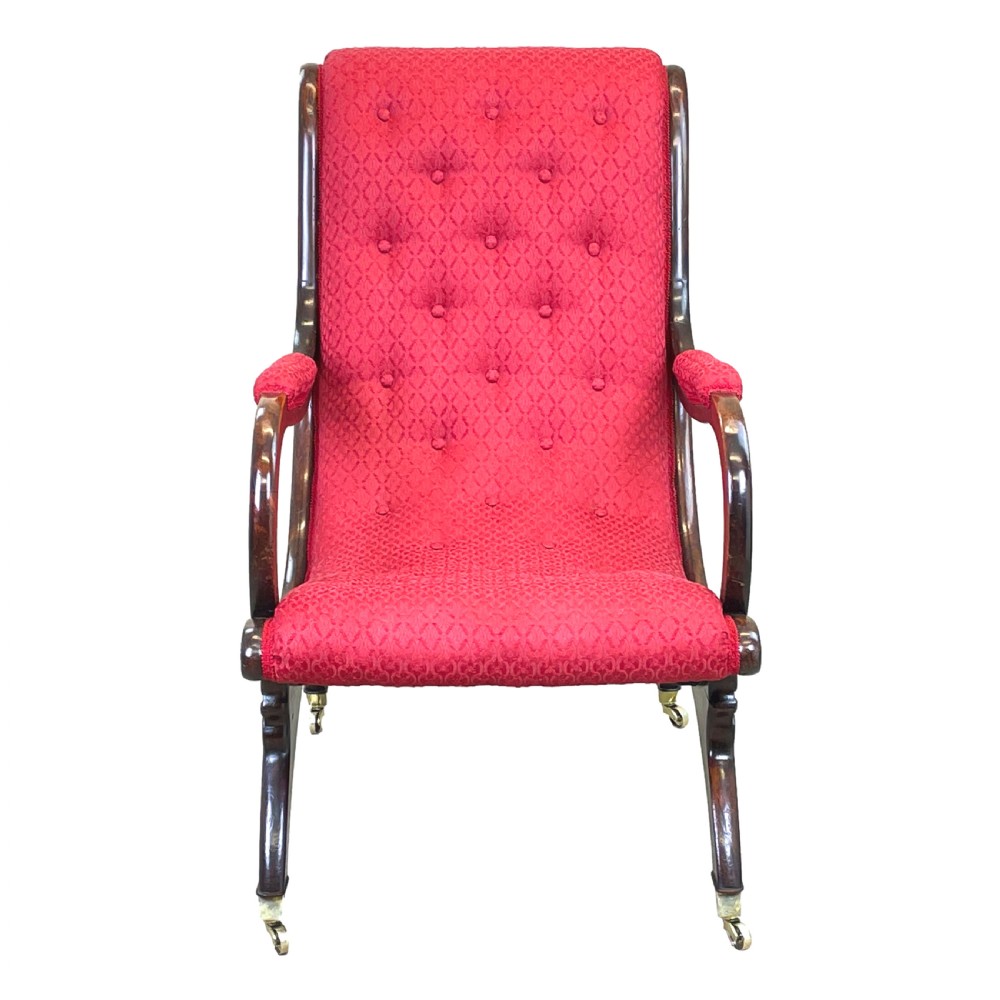 A Regency mahogany library armchair featuring button-backed red upholstery, curved scroll arms, and brass castors. View IX
