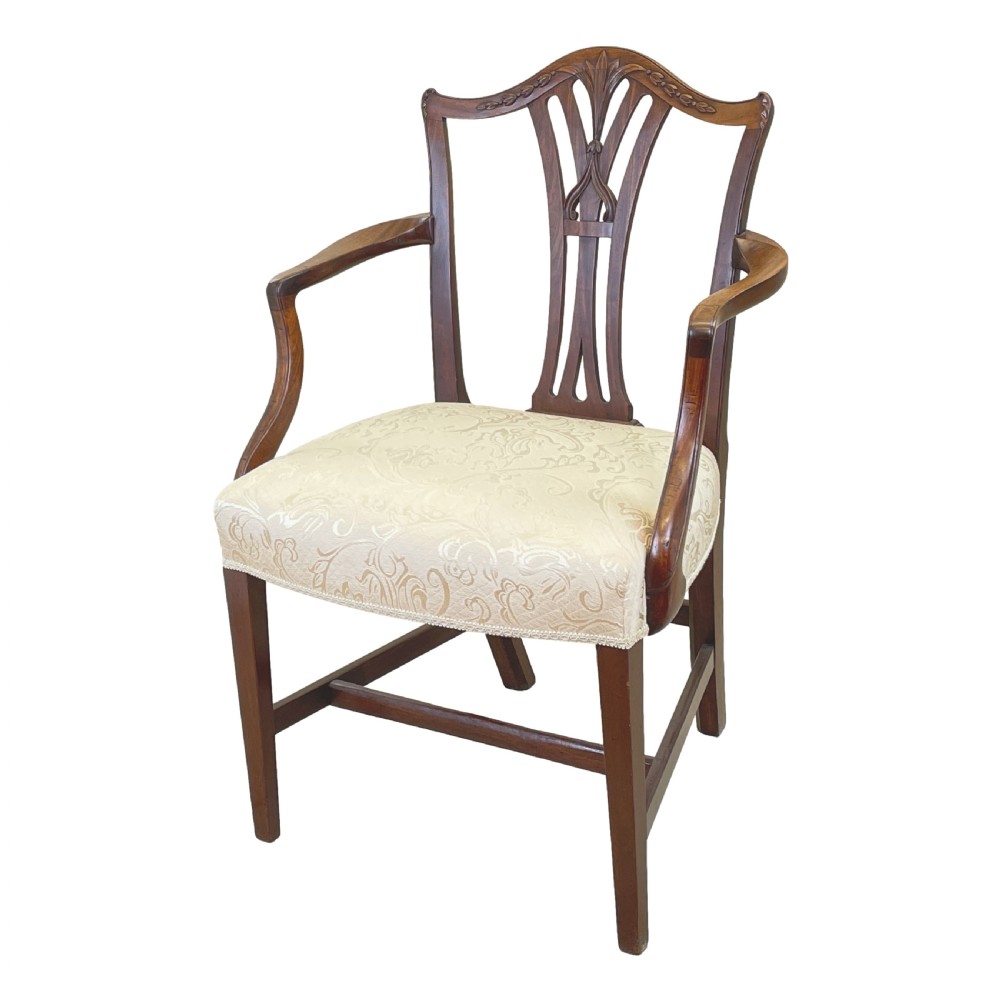 An 18th-century Georgian carved mahogany open armchair with a pierced back splat and cream patterned upholstered seat.