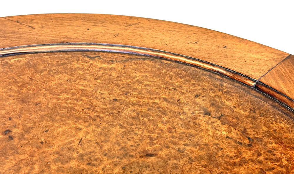 A low circular dark hardwood coffee table featuring hand-carved foliage and animal relief designs along the apron and supported by cabriole legs. View III