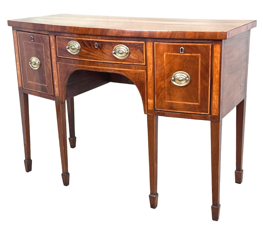 An 18th-century Georgian mahogany bowfront sideboard featuring a gently curved front, satinwood inlay, brass oval handles, and square tapered legs with spade feet. View II