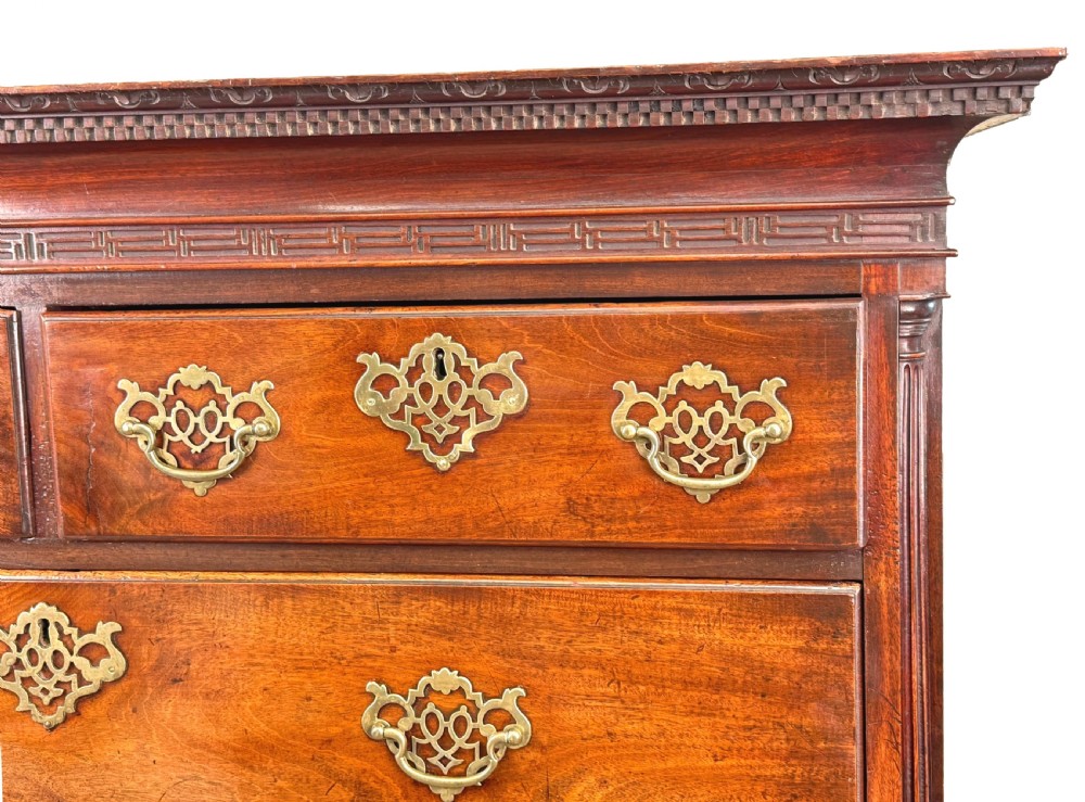 An 18th-century Chippendale mahogany tallboy chest-on-chest featuring Greek key fretwork moulding, brass handles, and bracket feet. View V