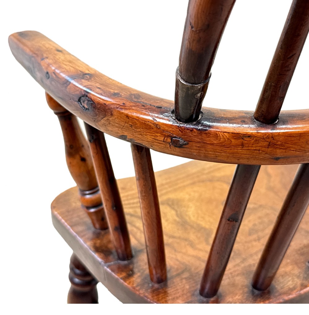 An antique child-sized Windsor armchair made of warm brown wood with turned legs, a hoop back, and a central pierced splat. View VIII