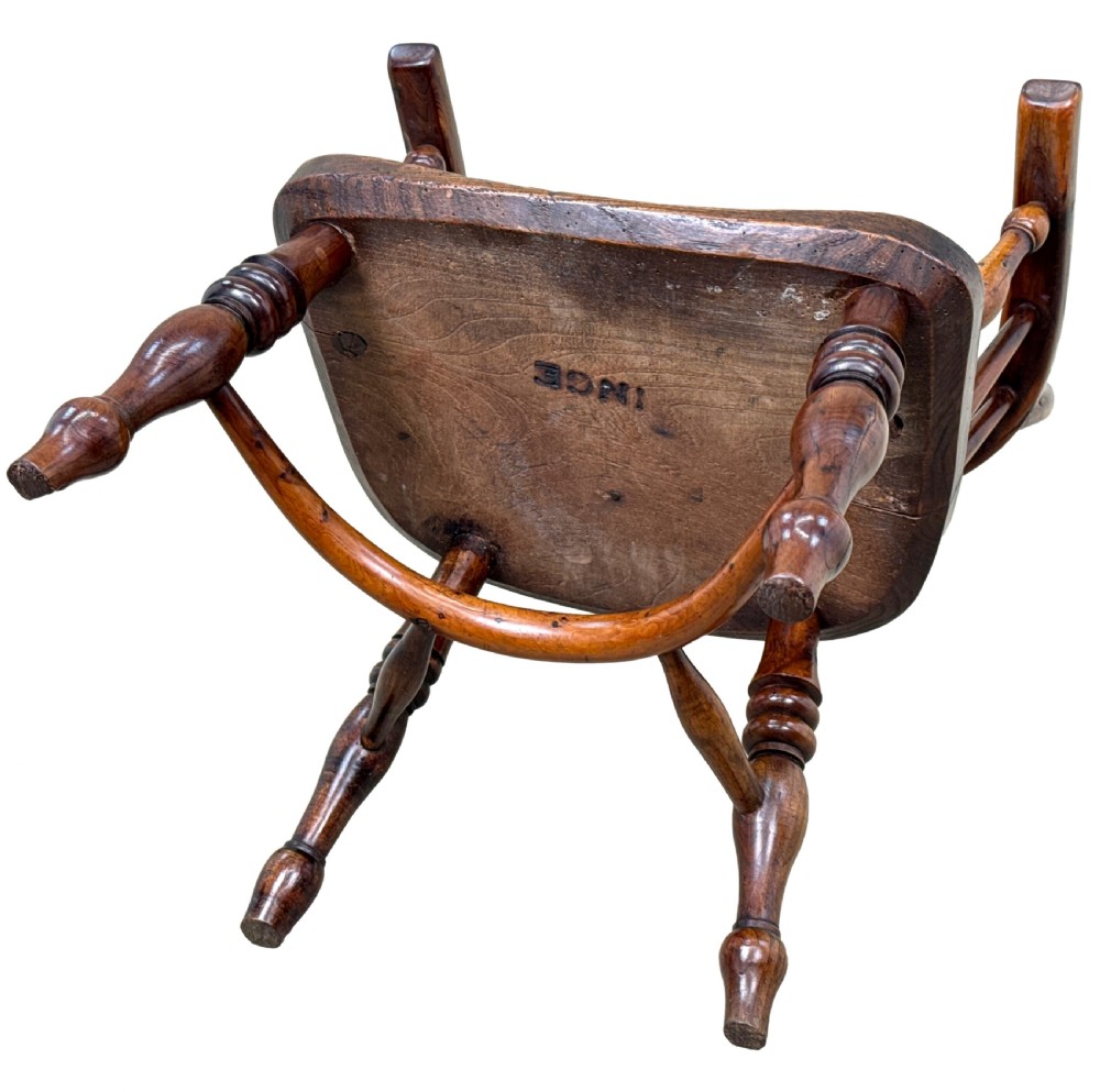 An antique child-sized Windsor armchair made of warm brown wood with turned legs, a hoop back, and a central pierced splat. View XIII