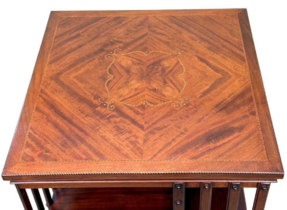 A late 19th-century square mahogany revolving bookcase featuring vertical slatted sides, open shelves, and a castored base. View IV
