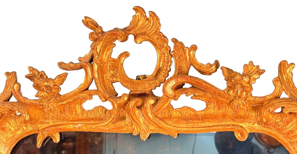 An ornate giltwood wall mirror in the Rococo style featuring asymmetrical scrollwork, acanthus leaves, and a pierced carved crest. View IV