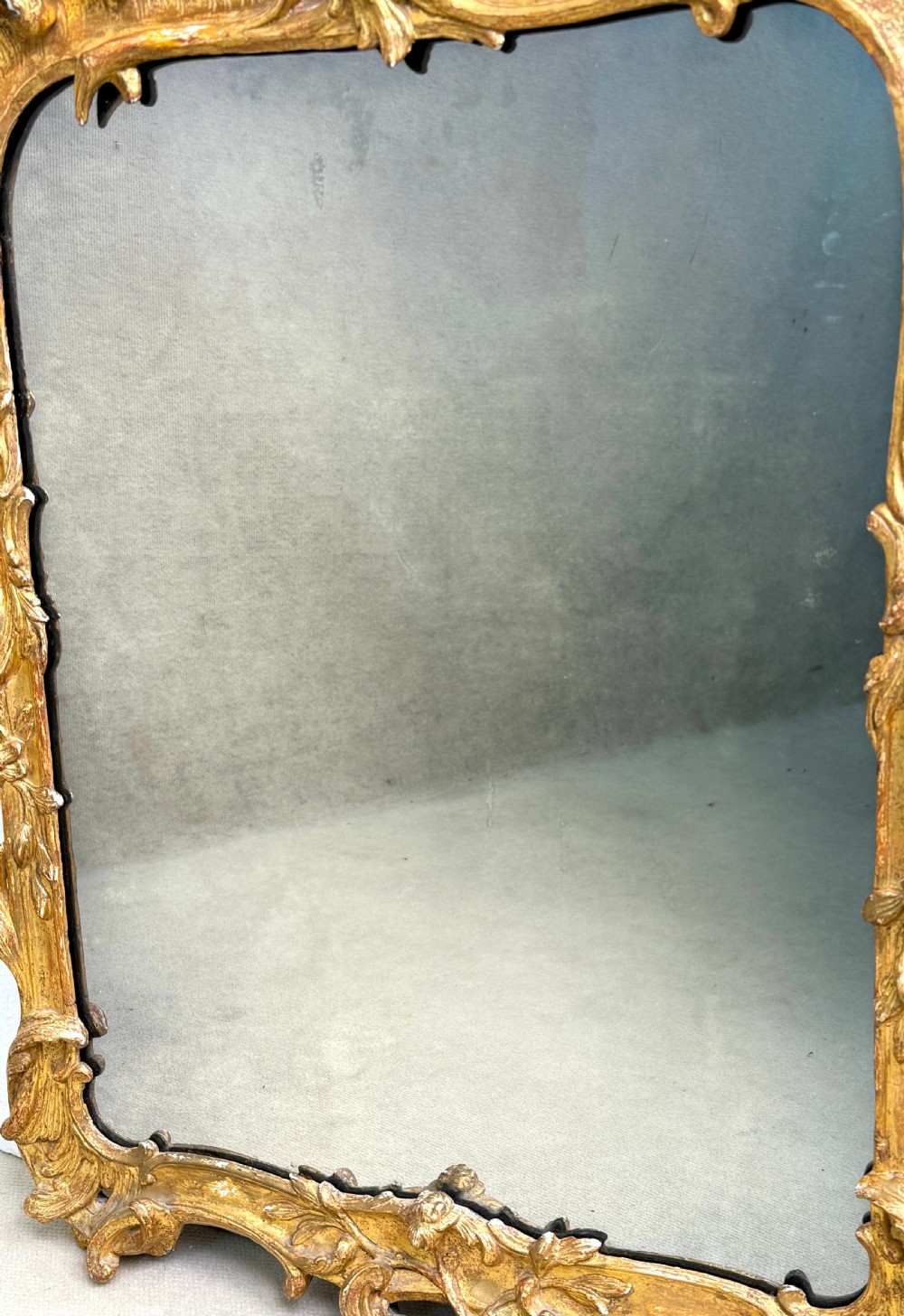 An ornate giltwood wall mirror in the Rococo style featuring asymmetrical scrollwork, acanthus leaves, and a pierced carved crest. View VIII