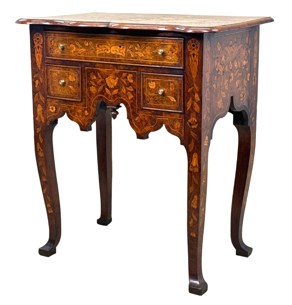 An 18th-century walnut lowboy side table decorated with intricate floral marquetry, featuring four drawers, a shaped apron with a drop finial, and cabriole legs.