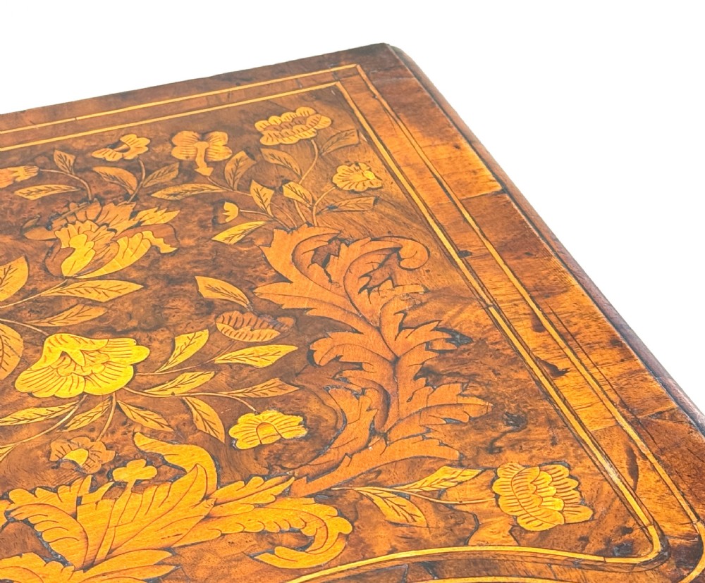 An 18th-century walnut lowboy side table decorated with intricate floral marquetry, featuring four drawers, a shaped apron with a drop finial, and cabriole legs. View XI