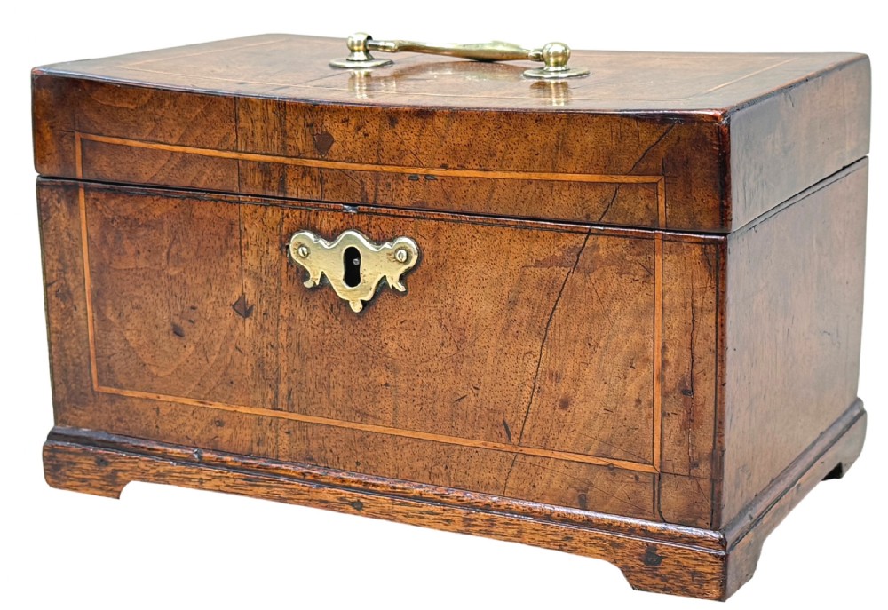 An 18th-century rectangular Georgian walnut tea caddy featuring herringbone stringing, a brass carrying handle on the lid, and a shaped brass escutcheon on the front face.