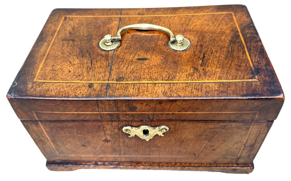 An 18th-century rectangular Georgian walnut tea caddy featuring herringbone stringing, a brass carrying handle on the lid, and a shaped brass escutcheon on the front face. View III