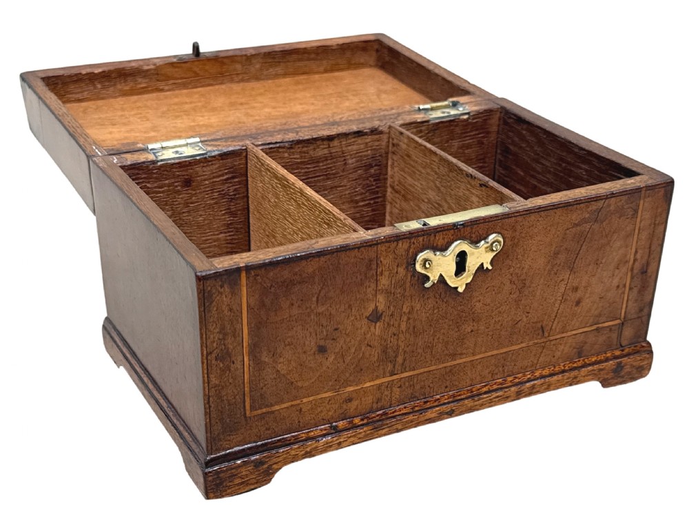 An 18th-century rectangular Georgian walnut tea caddy featuring herringbone stringing, a brass carrying handle on the lid, and a shaped brass escutcheon on the front face. View VI
