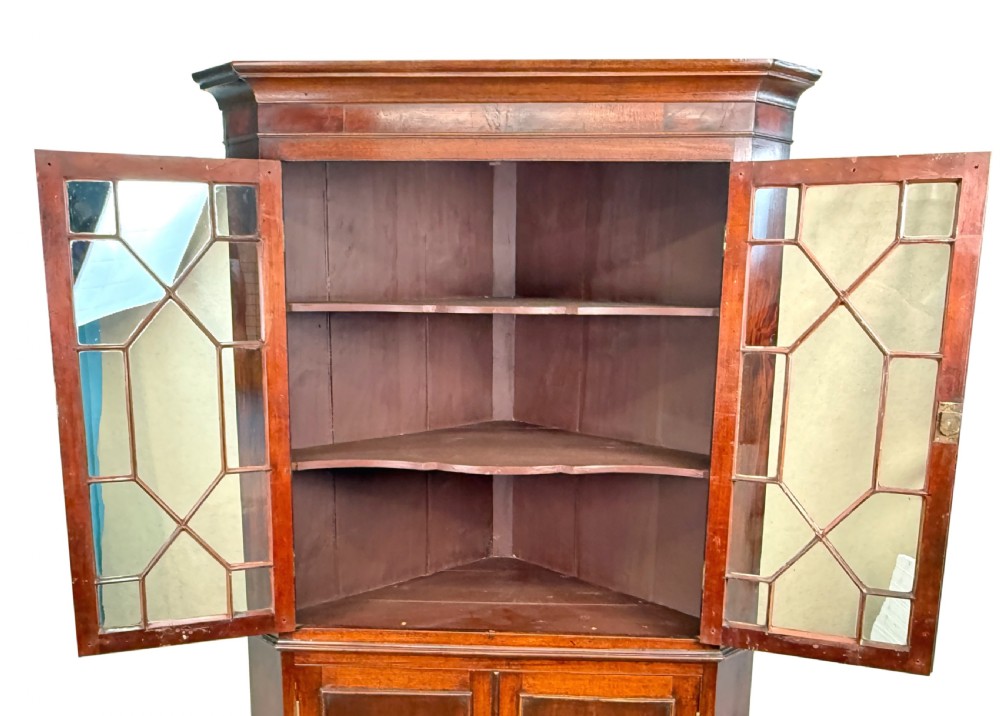 A tall two-part Georgian mahogany corner cabinet featuring upper astragal glazed doors and panelled lower doors. View VII