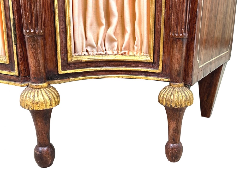An antique Regency style breakfront side cabinet featuring simulated rosewood finishing, gold leaf gilded columns, and doors set with pleated pink fabric. View XI