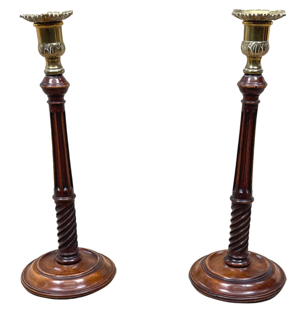 A pair of 18th-century mahogany candlesticks featuring fluted and spiral-twisted stems with brass nozzles set on circular turned bases. View VIII