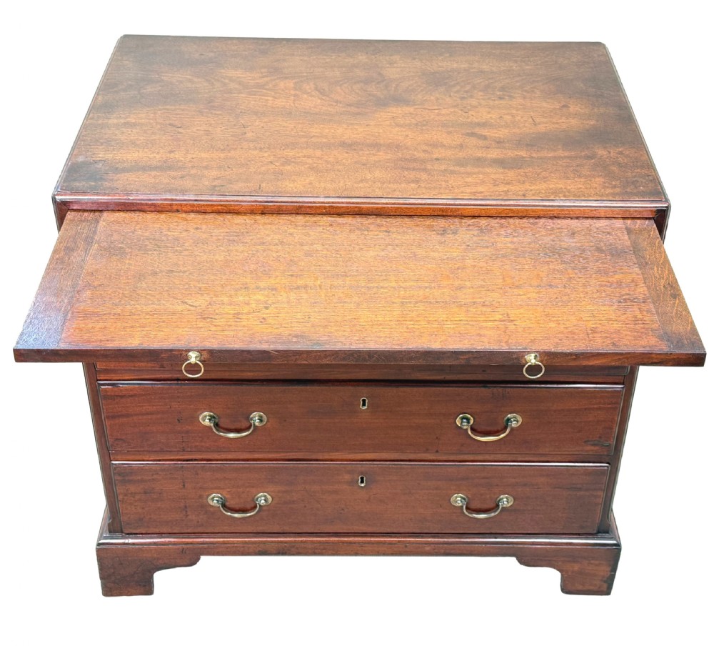 An 18th-century Georgian mahogany chest of drawers featuring four graduated drawers, brass swan-neck handles, a pull-out brushing slide, and sturdy bracket feet. View V