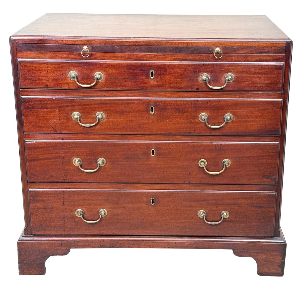 An 18th-century Georgian mahogany chest of drawers featuring four graduated drawers, brass swan-neck handles, a pull-out brushing slide, and sturdy bracket feet. View XII