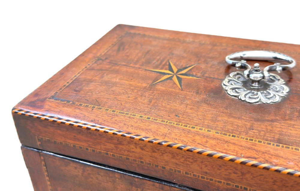 A rectangular 18th-century mahogany tea caddy featuring inlaid wooden star motifs on the front panel and a brass ring handle on top. View IV