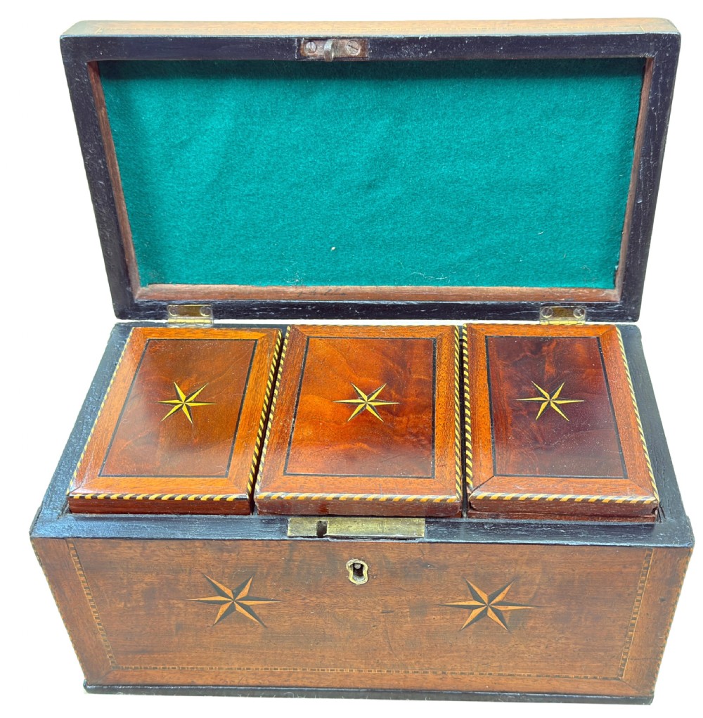 A rectangular 18th-century mahogany tea caddy featuring inlaid wooden star motifs on the front panel and a brass ring handle on top. View V