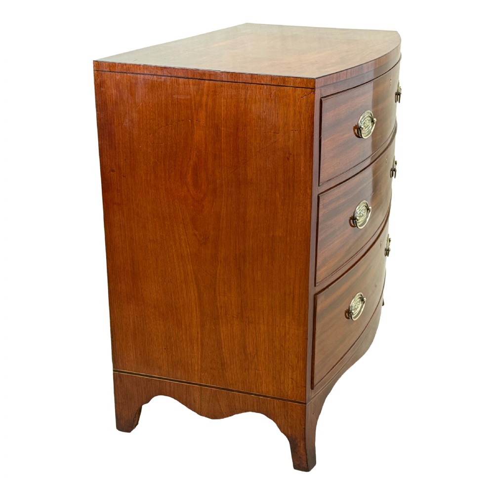 An 18th century George III mahogany bowfront chest of drawers with three graduated drawers and splayed bracket feet. View VI