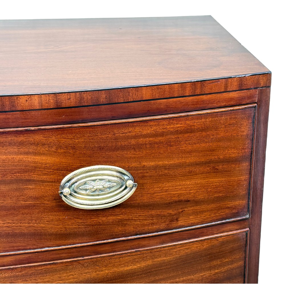 An 18th century George III mahogany bowfront chest of drawers with three graduated drawers and splayed bracket feet. View VIII