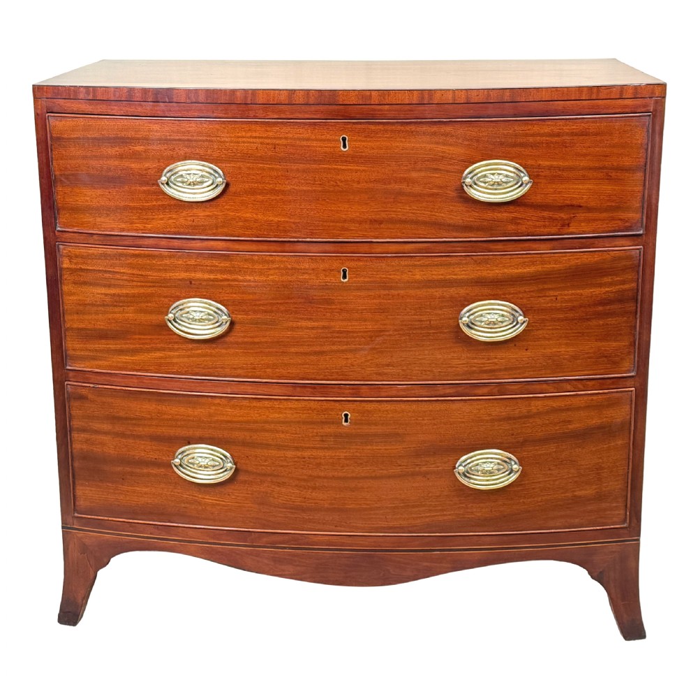 An 18th century George III mahogany bowfront chest of drawers with three graduated drawers and splayed bracket feet. View XI