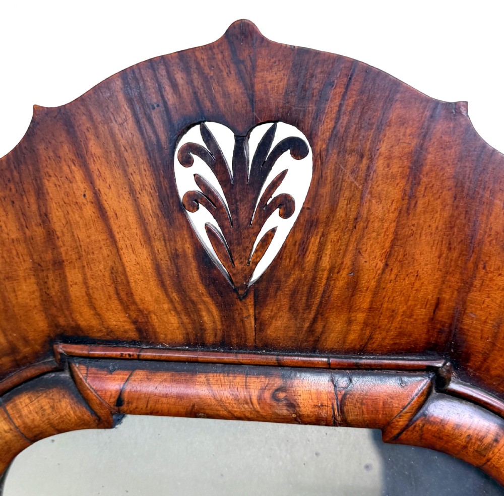 An early 18th-century Georgian walnut dressing table mirror featuring a shaped carved cresting, turned supports, and a base with miniature drawers and a central arch. View VII