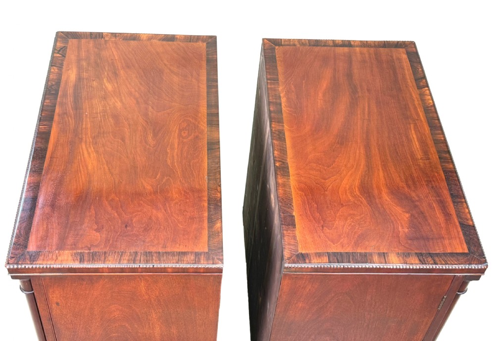 A pair of matching Regency mahogany side cupboards featuring flame veneer panel doors, flanking columns, and turned ball feet. View IV