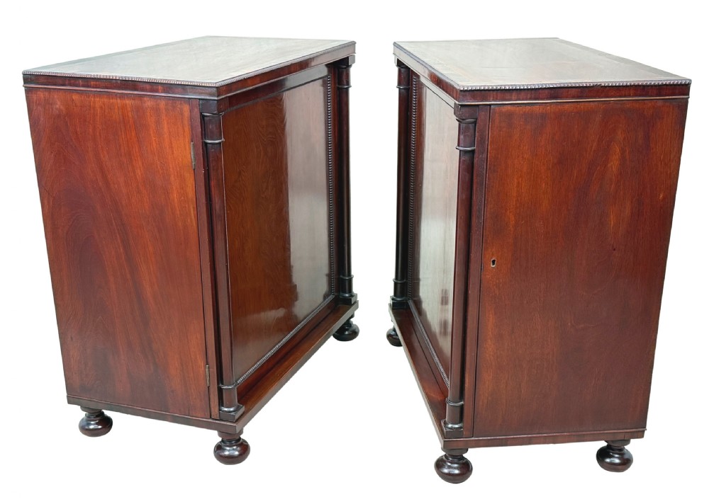 A pair of matching Regency mahogany side cupboards featuring flame veneer panel doors, flanking columns, and turned ball feet. View V