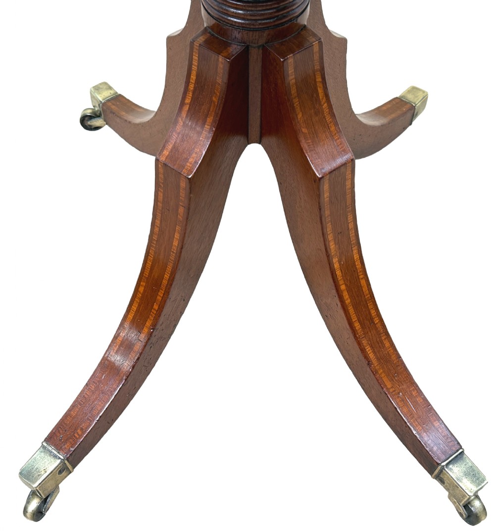 A Georgian mahogany baby Pembroke table with two drop leaves, double drawers with inlay, a turned central pedestal, and sabre tripod legs on brass castors. View VII