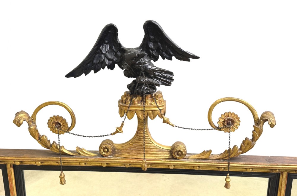 A Regency giltwood tripartite overmantel mirror featuring ball moulding details, ebonised inner slips, and an ebonised eagle crest surmount. View VIII