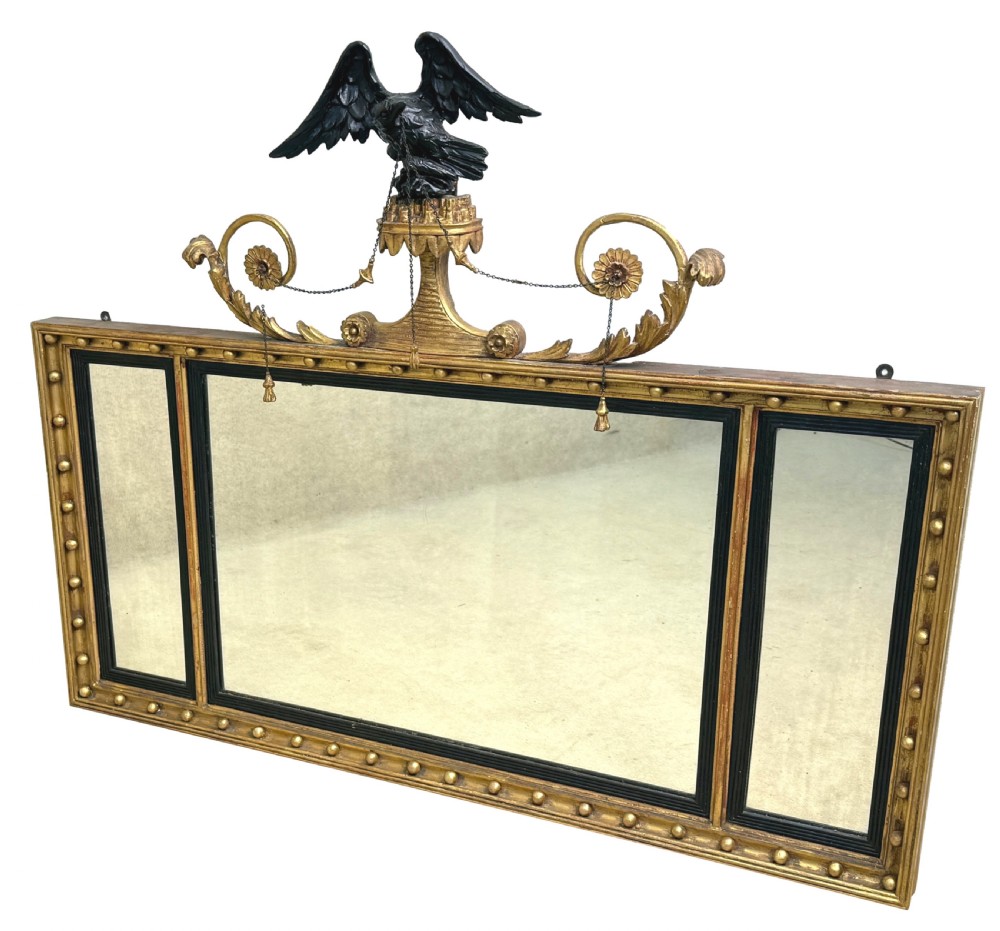 A Regency giltwood tripartite overmantel mirror featuring ball moulding details, ebonised inner slips, and an ebonised eagle crest surmount. View XI