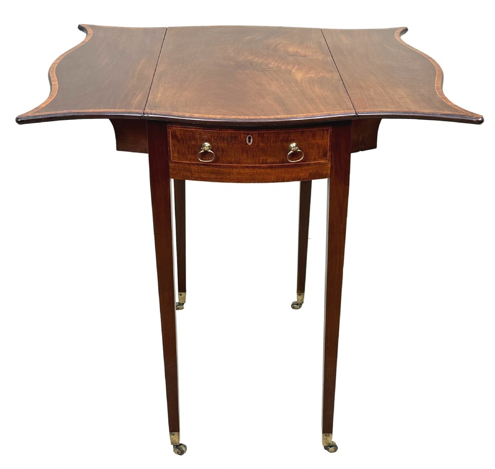 An 18th-century Hepplewhite mahogany Pembroke table with extended shaped drop leaves, a single drawer, and tapered legs on brass castors. View XIII
