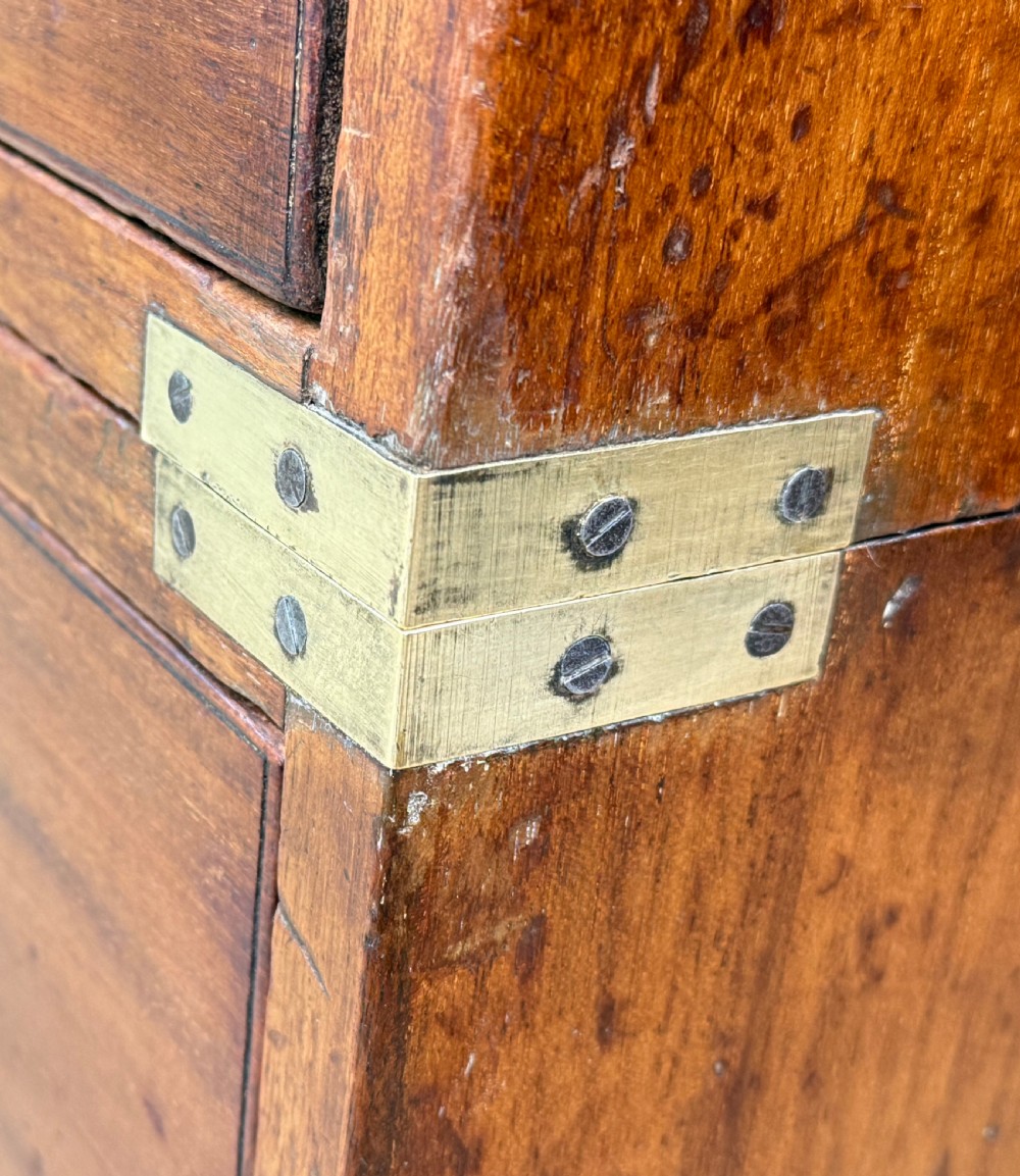 A nineteenth-century camphor wood military campaign chest of drawers featuring flush brass handles, corner brackets, and turned bun feet. View VIII