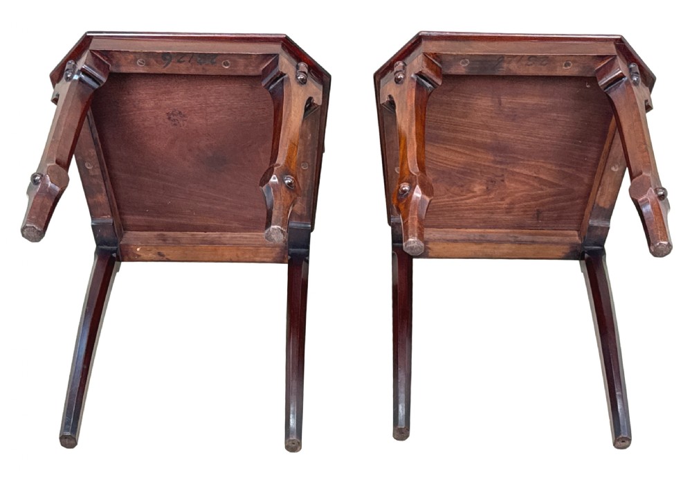 A pair of Victorian mahogany hall chairs featuring carved shield backrests, open architectural arches, turned finials, and solid wooden seats. View XII