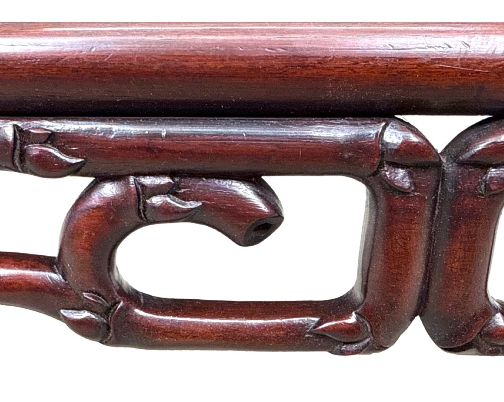 A 19th-century Chinese hardwood coffee table with a rectangular inset top, openwork carved bamboo apron, and low legs. View VI