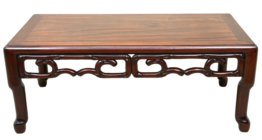 A 19th-century Chinese hardwood coffee table with a rectangular inset top, openwork carved bamboo apron, and low legs. View IX