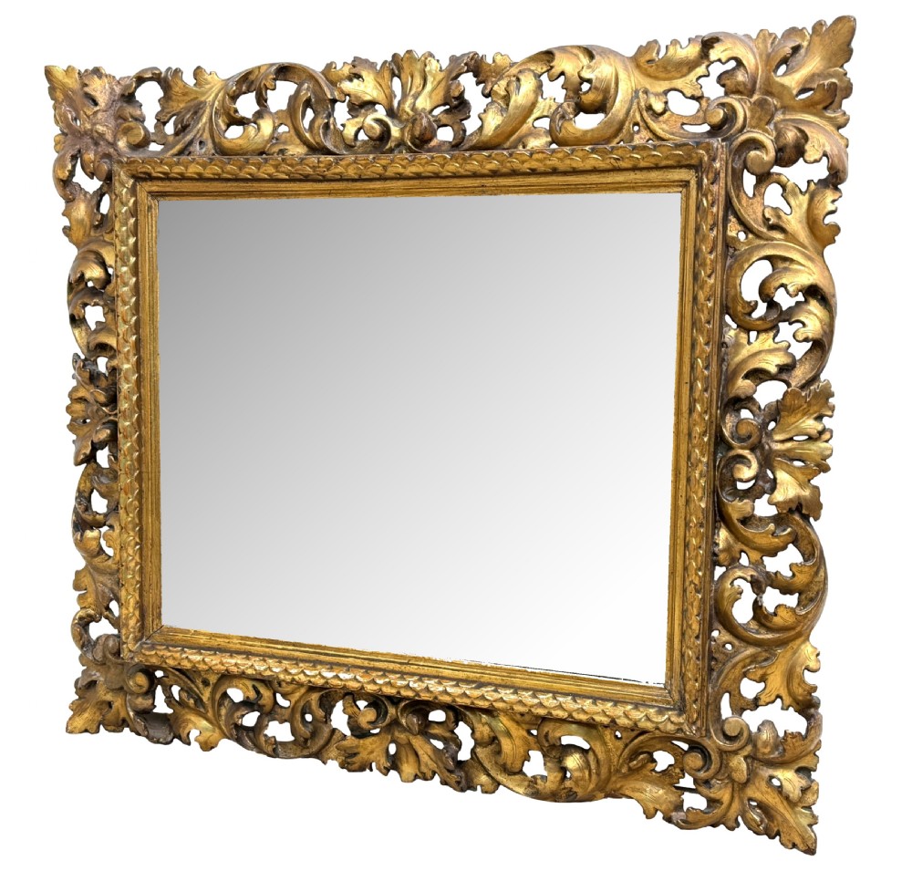 A 19th-century rectangular Italian Florentine mirror framed with deeply carved openwork gilded foliage and acanthus leaf details.