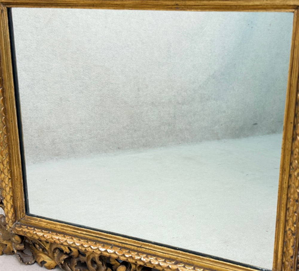 A 19th-century rectangular Italian Florentine mirror framed with deeply carved openwork gilded foliage and acanthus leaf details. View IV