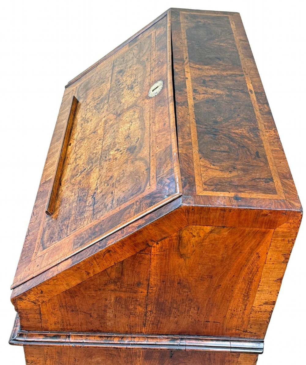 An early 18th-century Queen Anne walnut bureau featuring a slanted fall-front writing flap, brass escutcheons with drop handles, and turned bun feet. View II