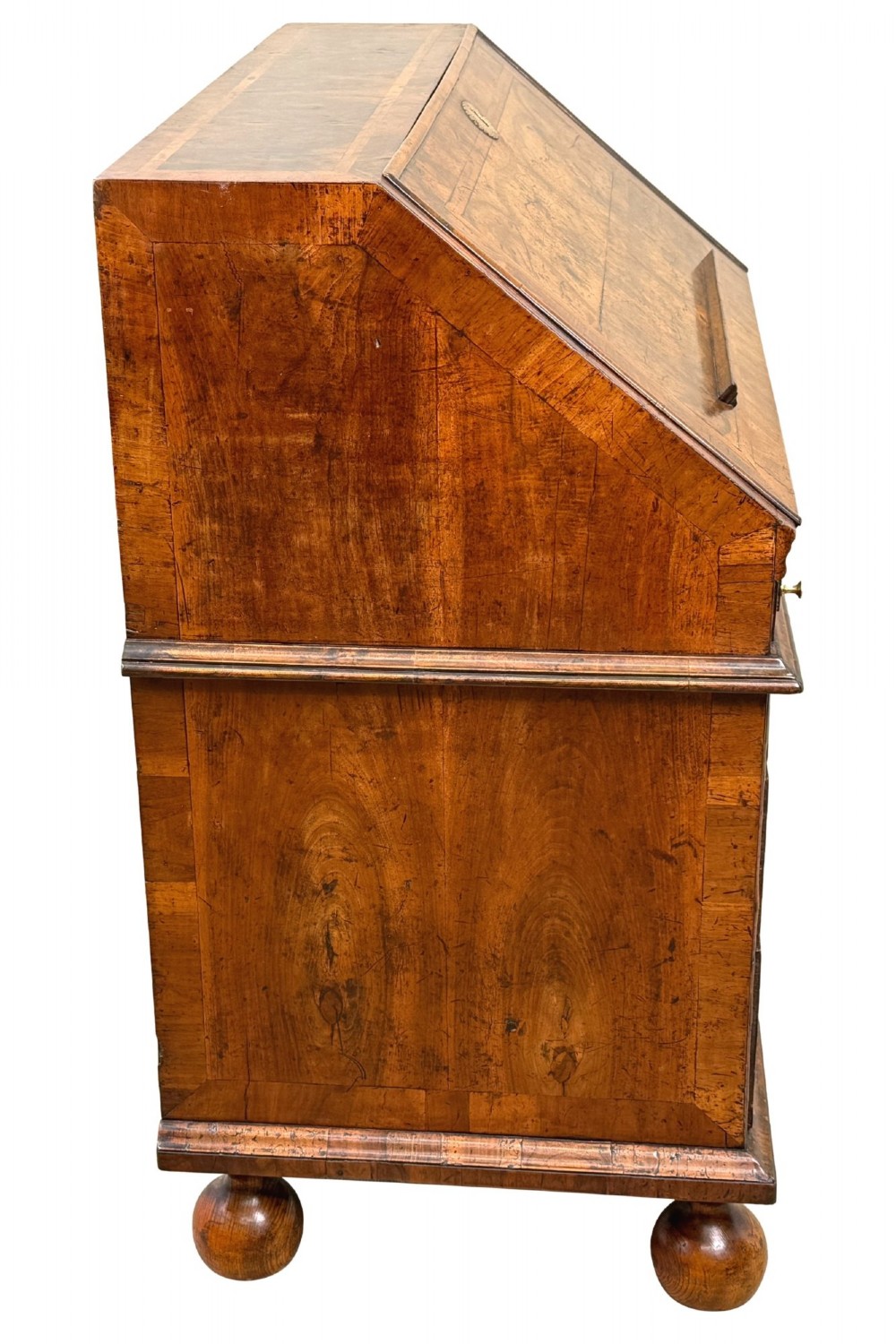 An early 18th-century Queen Anne walnut bureau featuring a slanted fall-front writing flap, brass escutcheons with drop handles, and turned bun feet. View IX