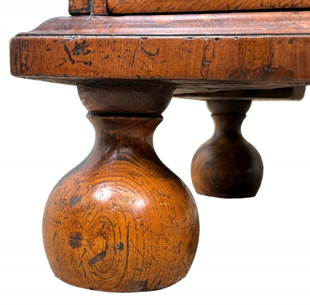 An early 18th-century Queen Anne walnut bureau featuring a slanted fall-front writing flap, brass escutcheons with drop handles, and turned bun feet. View XIV