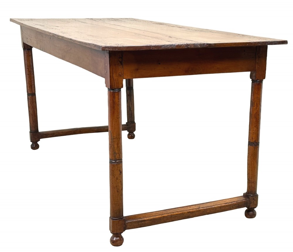 A 19th-century French Provincial fruitwood farmhouse table featuring a rectangular plank top, single end drawer, turned legs, and lower side stretchers. View V