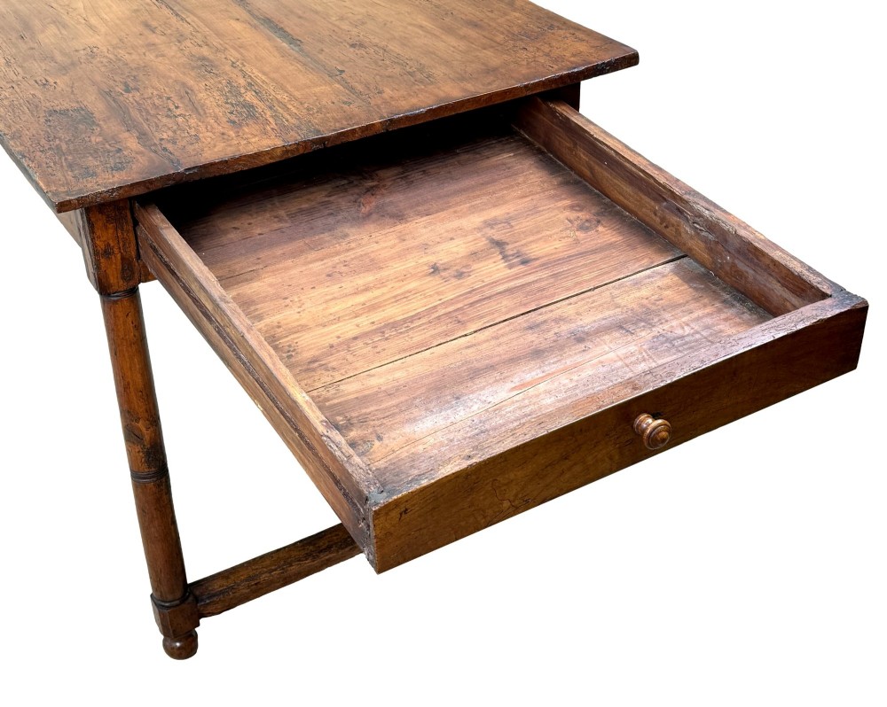A 19th-century French Provincial fruitwood farmhouse table featuring a rectangular plank top, single end drawer, turned legs, and lower side stretchers. View VII