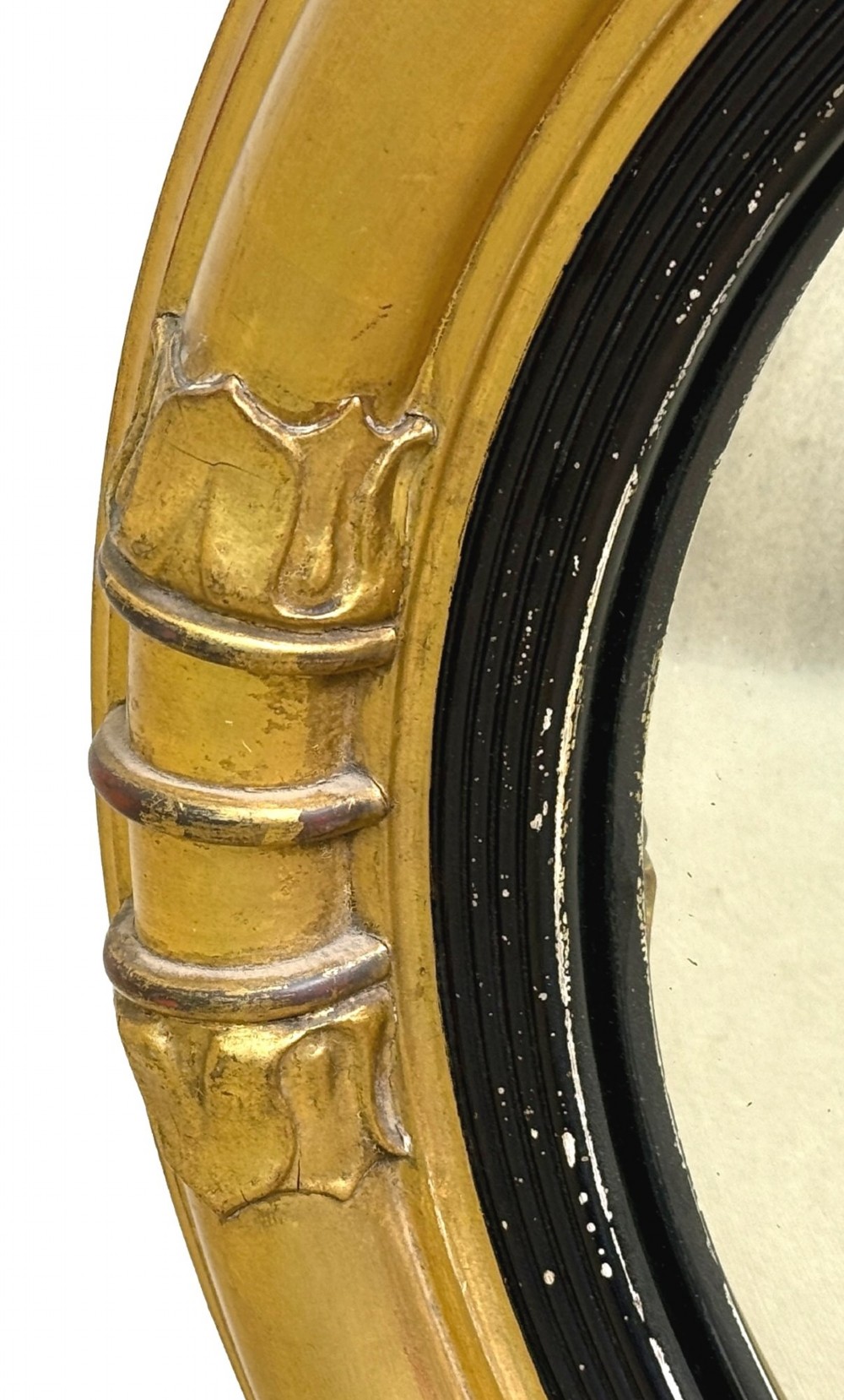 A mid-19th century circular convex mirror featuring a moulded giltwood frame with carved leaf clasps and an inner ebonised reeded slip. View III