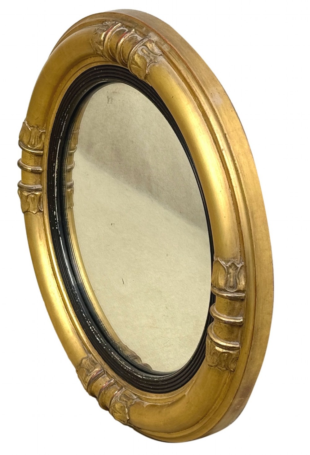 A mid-19th century circular convex mirror featuring a moulded giltwood frame with carved leaf clasps and an inner ebonised reeded slip. View VII