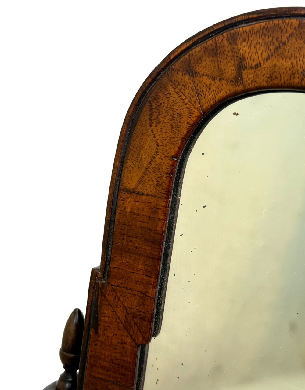 A Queen Anne early 18th-century walnut dressing table mirror featuring an arched swing frame resting above a stepped serpentine base with small drawers and brass hardware. View VIII