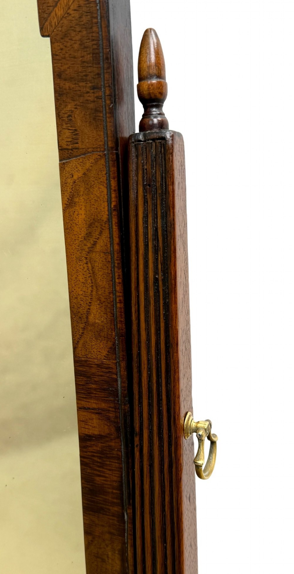 A Queen Anne early 18th-century walnut dressing table mirror featuring an arched swing frame resting above a stepped serpentine base with small drawers and brass hardware. View XII