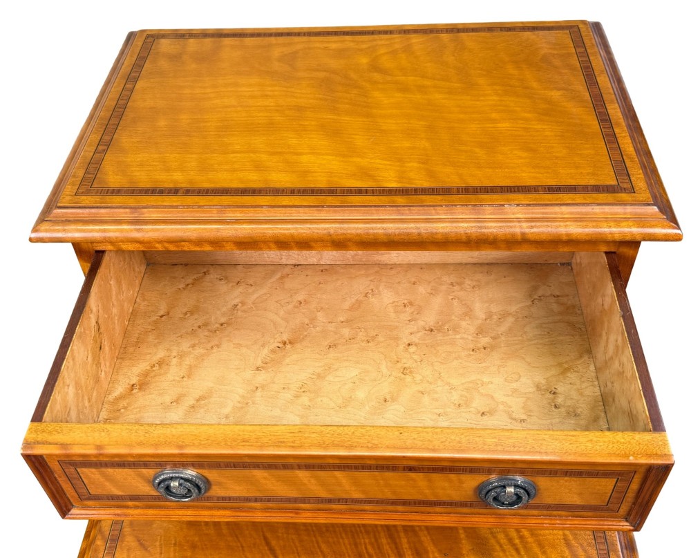 A pair of 19th-century golden satinwood bedside chests featuring stepped top sections with drawers, crossbanded inlay, and brass ring handles. View IV